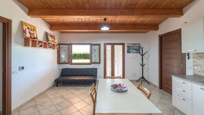 Un espace repas comprenant une table, des chaises, un canapé et un ventilateur de plafond.
