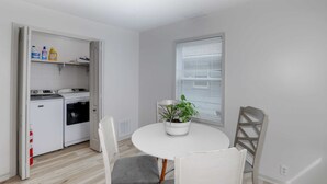 A compact kitchen with a washing machine, a drying machine, and a potted plant on a table. - Spacious West Side Home away from Home! (Wichita)
