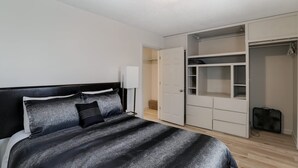 A bedroom with a bed, a wardrobe, and a walk-in closet. - Spacious West Side Home away from Home! (Wichita)