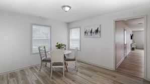A dining area with a round table, two chairs, and a potted plant. - Spacious West Side Home away from Home! (Wichita)