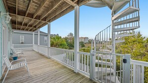 A wooden deck with white railings and a spiral staircase.