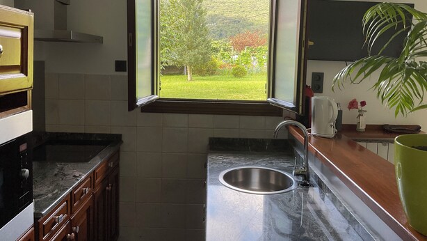 Una cocina con ventana, pileta y alacenas.