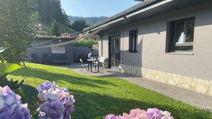 A house with a patio, a dining area, and a view of the surrounding landscape.