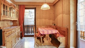 Un intérieur en bois avec une table à manger, des placards et une grande fenêtre.