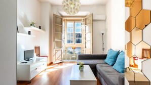 Ein modernes Wohnzimmer mit einer Couch, einem Couchtisch und einem Fernseher.
