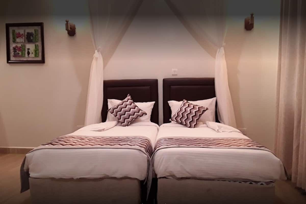 Ein Doppelbett mit Baldachin, zwei Nachttische und ein gerahmtes Bild an der Wand.