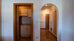 Ein Korridor mit gewölbter Decke, Holzschränken und Fliesenboden.