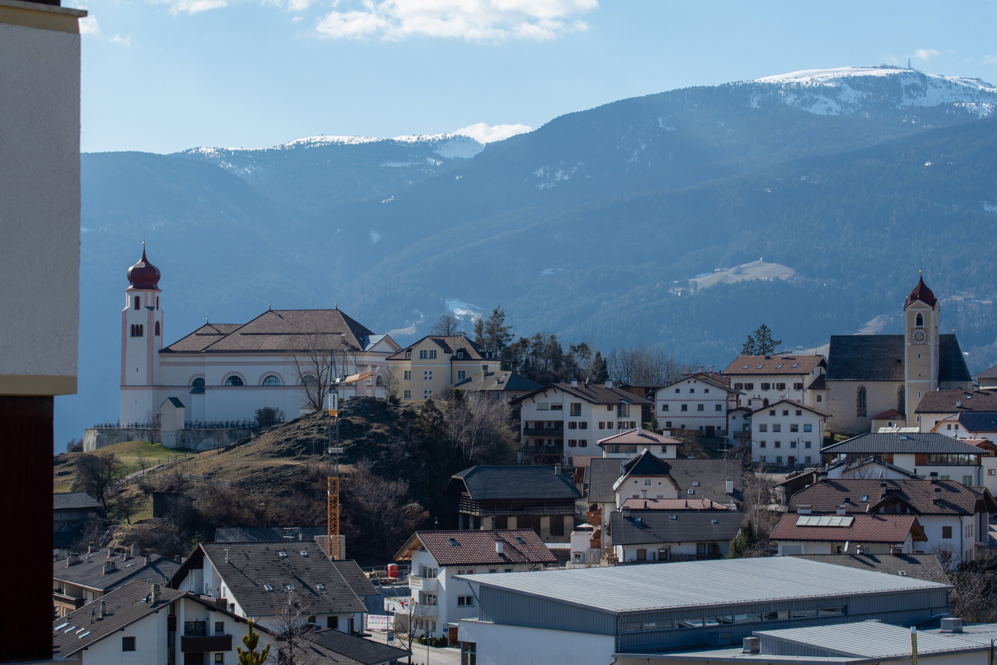 Une ville qui se distingue par son église imposante et son cadre montagneux.