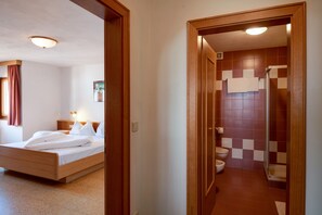 Une chambre d’hôtel comprenant un lit, une table de chevet et une salle de bain avec douche et toilettes.