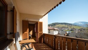 Een balkon met uitzicht op een stad en bergen.