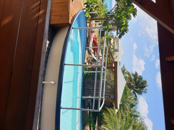 Relax by the pool with a view of the surrounding building and lush palm trees.