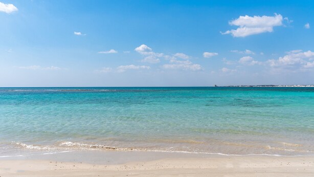 Una spiaggia con acque cristalline color turchese e una riva sabbiosa.