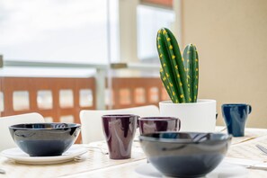 A dining table with a potted cactus, bowls, and cups. - Holiday Apartment Luxury Junto Al Mar close to the Beach with Terrace (EL MEDANO)