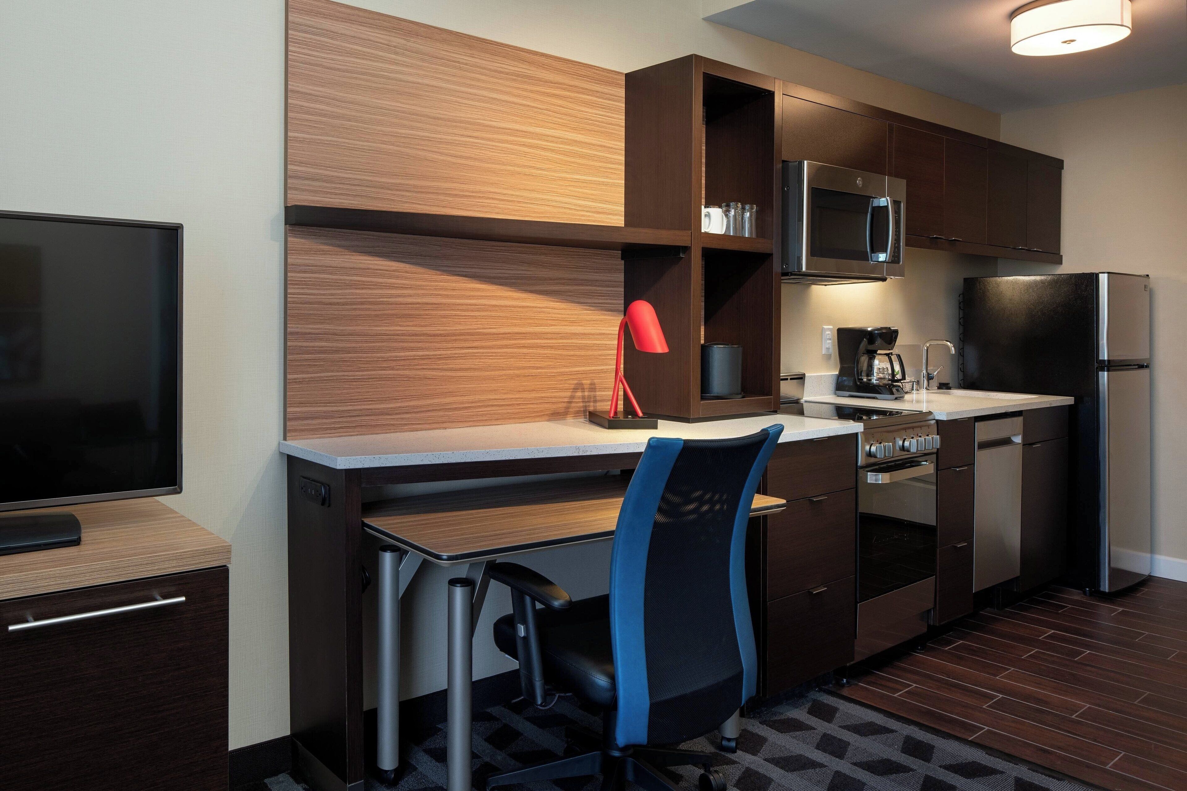 A compact kitchen with a microwave, coffee maker, and refrigerator.