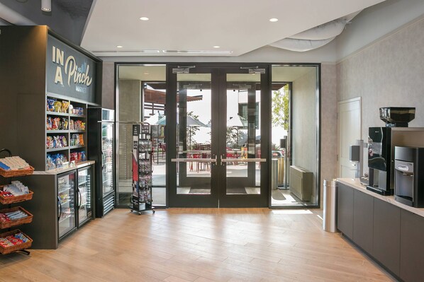 A modern interior with a coffee machine, a refrigerator, and a shelf with snacks. - TownePlace Suites by Marriott Nashville Downtown/Capitol District (Nashville)