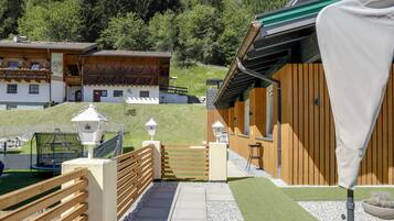 Un bâtiment en bois doté d’un balcon, d’une clôture en bois et d’un chemin pavé menant à un portail.