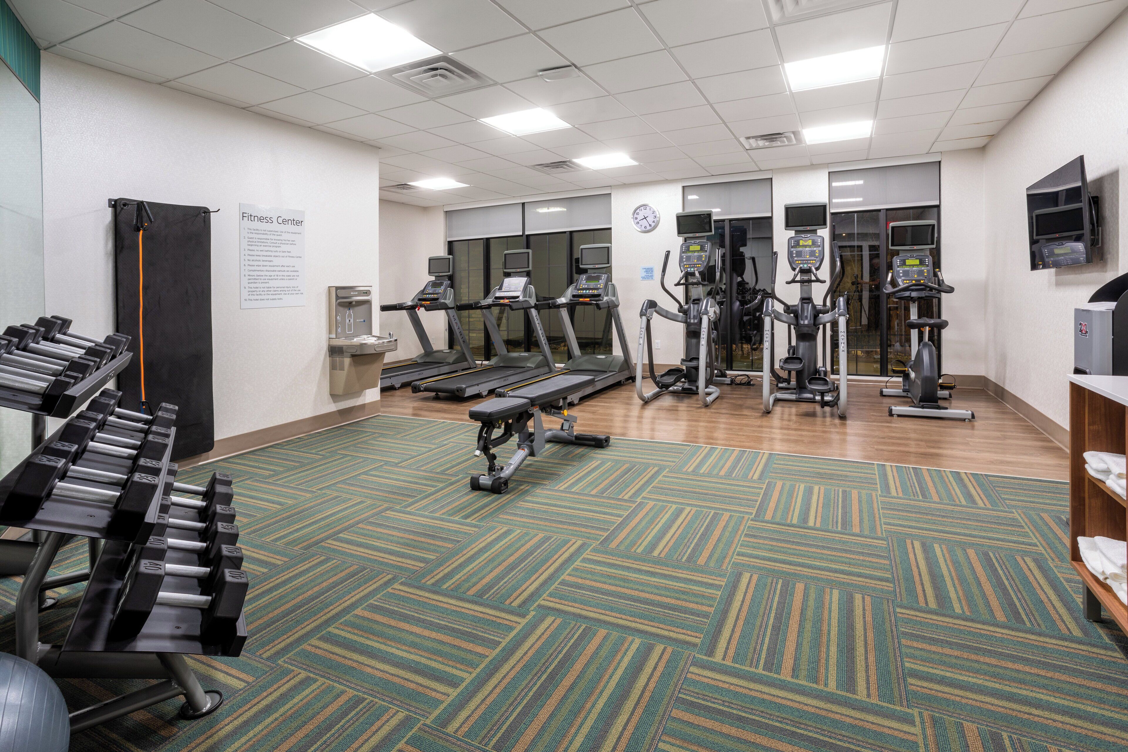 A fitness center with treadmills, elliptical machines, and weightlifting equipment.