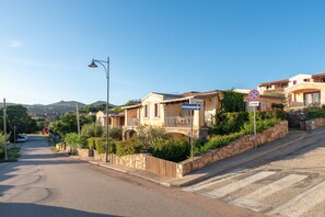 Una strada residenziale con case, un segnale di divieto di parcheggio e un lampione.