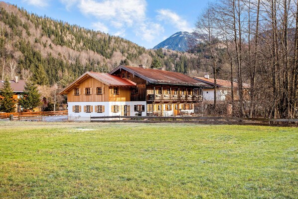 Un chalet en bois doté d’un balcon, situé dans un cadre montagneux.