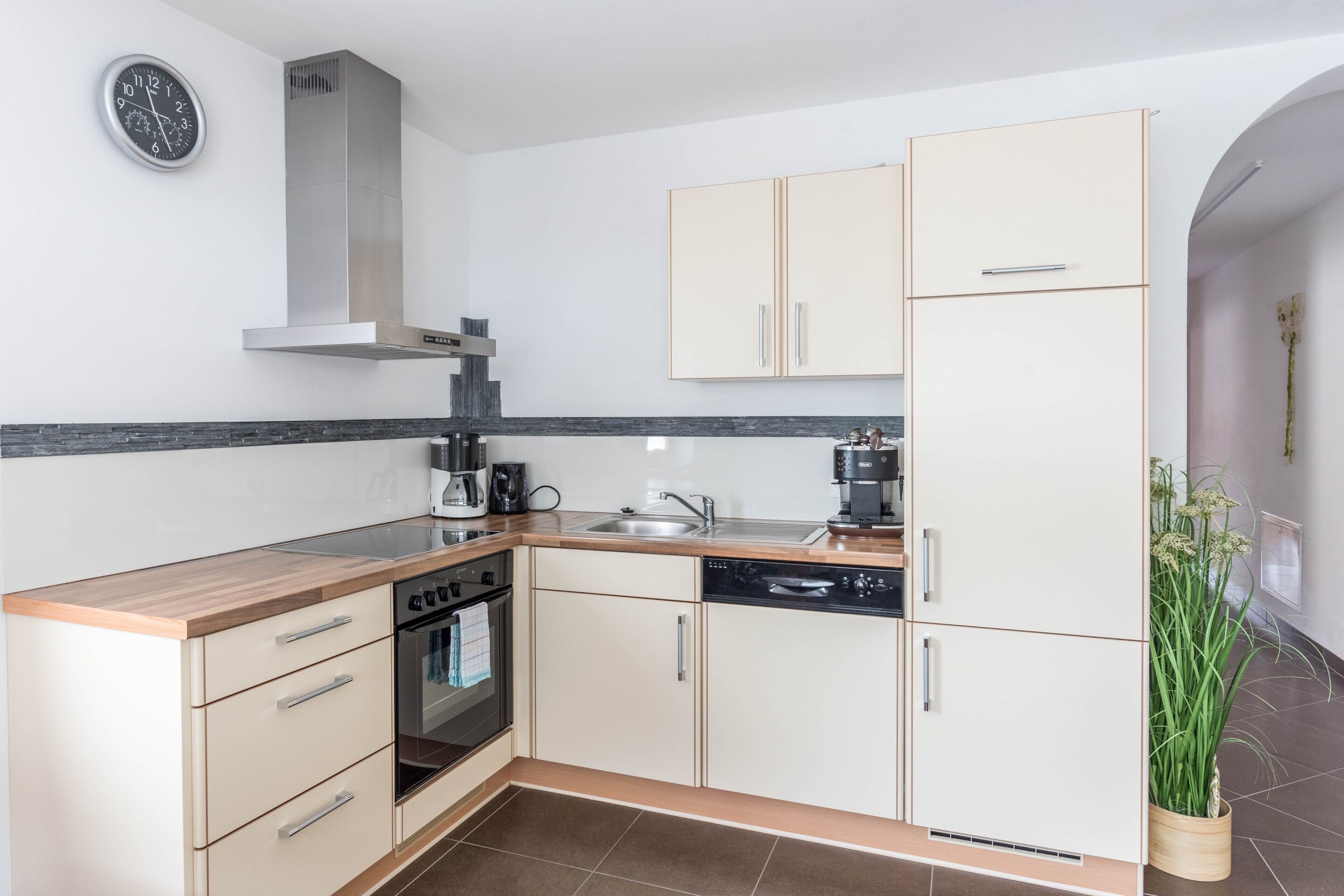 A modern kitchen with a stove, oven, sink, and cabinets.