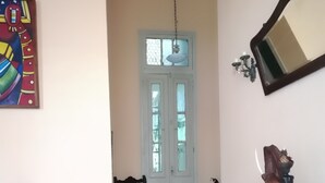 Ett rum med ett mönstrat golv, en trästol, en röd soffa och en dekorativ elefantstaty.