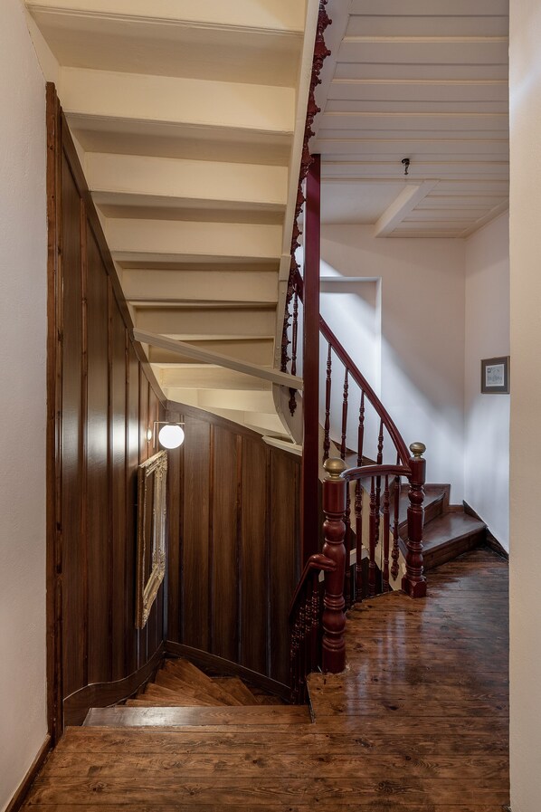 A wooden staircase with a white ceiling and a picture frame on the wall. - Old Town Suites (Chania)