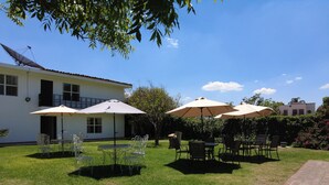 A courtyard with outdoor seating, a satellite dish, and a building with a balcony.