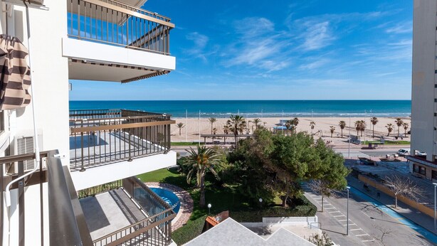 Un immeuble de grande hauteur doté de balcons donnant sur une plage.