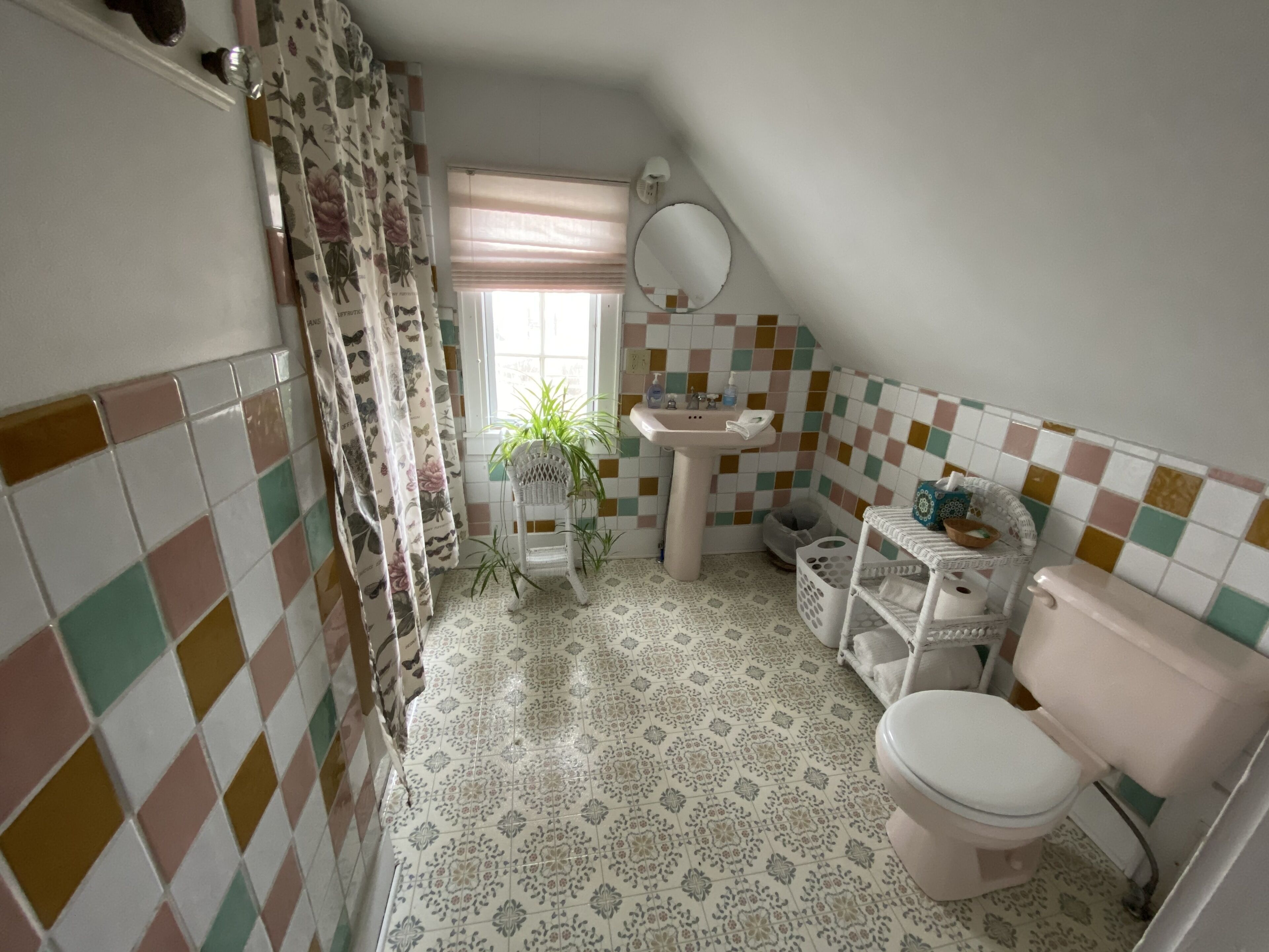 Et badeværelse med toilet, vask og bruseniche.