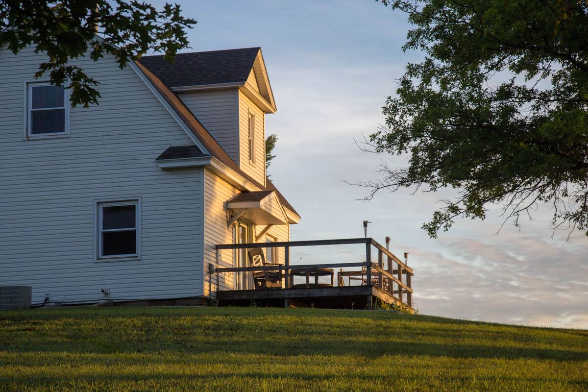 A two-story house with a porch and a small deck.