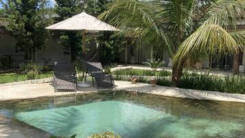 Een buitenzwembad en een zwembad met een waterval