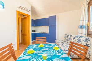 A compact living space with a dining area, a kitchenette, and a sofa. - Apartment Close to the Beach with Balcony, Sea View & Air Conditioning (Budoni)
