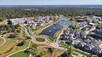 Vista aérea de una zona residencial con varios lagos, un edificio grande de fachada simétrica y céspedes y senderos bien cuidados.