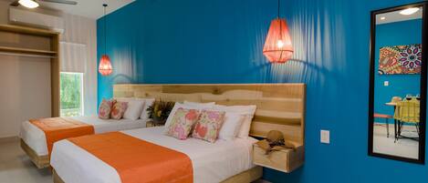 A bedroom with two beds, a wooden headboard, and a blue accent wall.