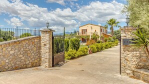 A stone wall, a metal gate, a paved driveway, and a building with a sign reading 'Canal.' - Holiday Home 'Ines' with Mountain View, Wi-Fi and Air Conditioning (INCA)