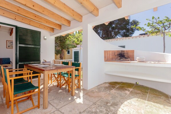 A covered patio with wooden furniture, a tiled floor, and a view of the outdoors. - Family home with shared pool and garden - Casa Son Xoriguer 5 (Son Xoriguer)
