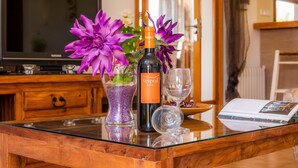 A table with a bottle of Vespral Crush wine, a glass, and a vase with purple flowers. - Beautiful Villa with Pool, Wi-Fi, Terraces, Garden and Gorgeous View; Parking Available (santanyi)