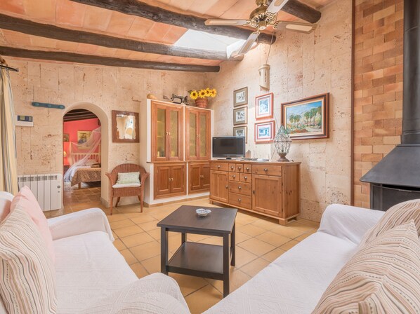 Un salon chaleureux avec une cheminée, des meubles en bois, un téléviseur et un coin repas.