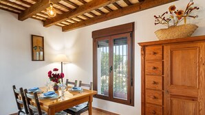 A dining area with a wooden table, chairs, a lamp, and a window with a view. - In a quiet location with sea view - El Mirador de Castilnovo (El Palmar (Cádiz))