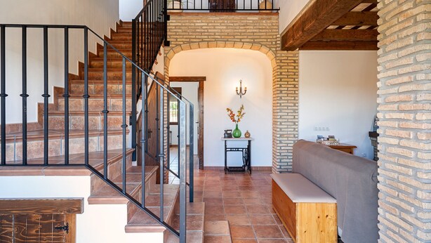 A staircase with a wooden finish, a bench, and a brick wall. - In a quiet location with sea view - El Mirador de Castilnovo (El Palmar (Cádiz))