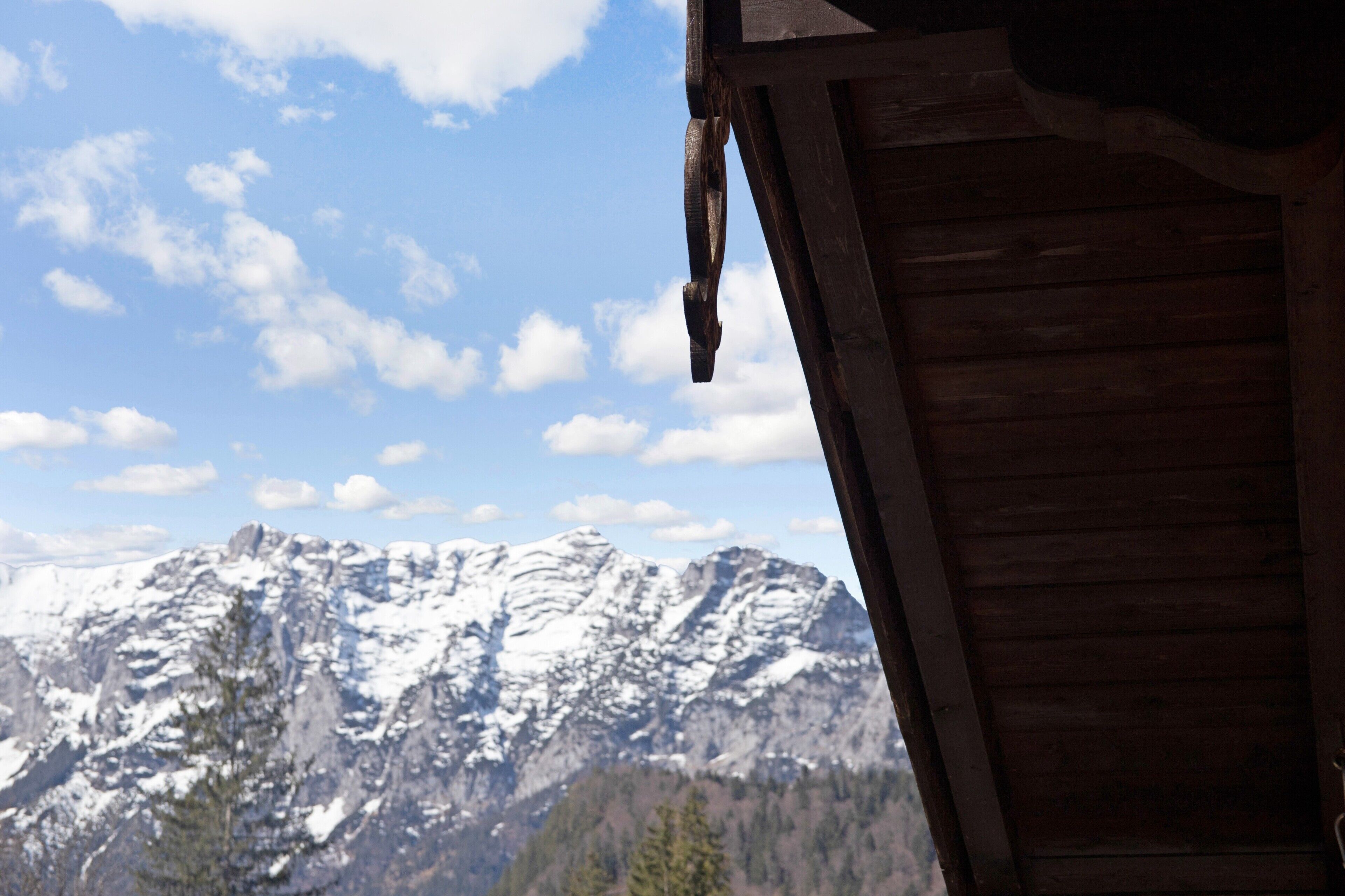 Una cabaña de madera con vistas a montañas nevadas.