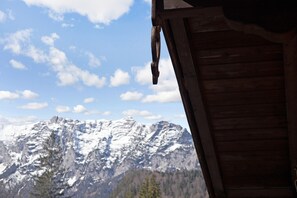 A wooden cabin with a view of snow-capped mountains.