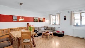 Ein Wohnzimmer mit einem Holzesstisch, einem Sofa und einem kleinen Couchtisch.