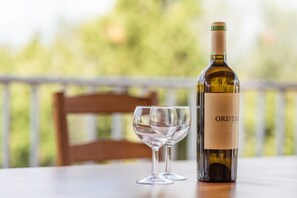 Une bouteille de vin et un verre à vin vide sur une table, avec un arrière-plan extérieur flou.