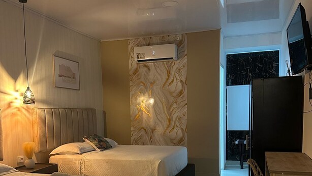 Een hotelkamer met twee bedden, een bureau en een televisie.