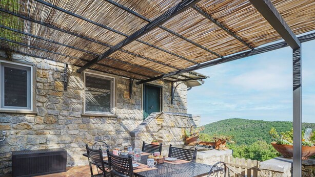 A stone building with a covered patio, outdoor seating, and a view of a green landscape. - Beautiful private villa for 6 people with WIFI, TV and terrace (Lerici)
