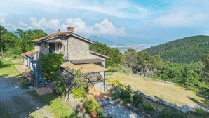 A stone house with a staircase, surrounded by lush greenery and a view of distant mountains. - Beautiful private villa for 6 people with WIFI, TV and terrace (Lerici)