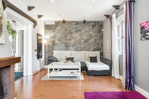 A living room with a stone wall, a sofa, a coffee table, and a fireplace.