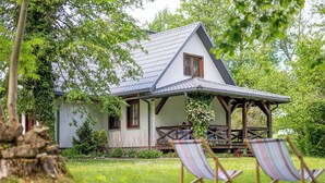 A house with a covered porch, two chairs, and a tree in the foreground. - Wonderful private villa for 6 people with terrace and pets allowed (Zatyle)