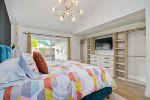 Ein Schlafzimmer mit einem Bett, einem Fernseher, einem Kleiderschrank und einer Deckenleuchte.